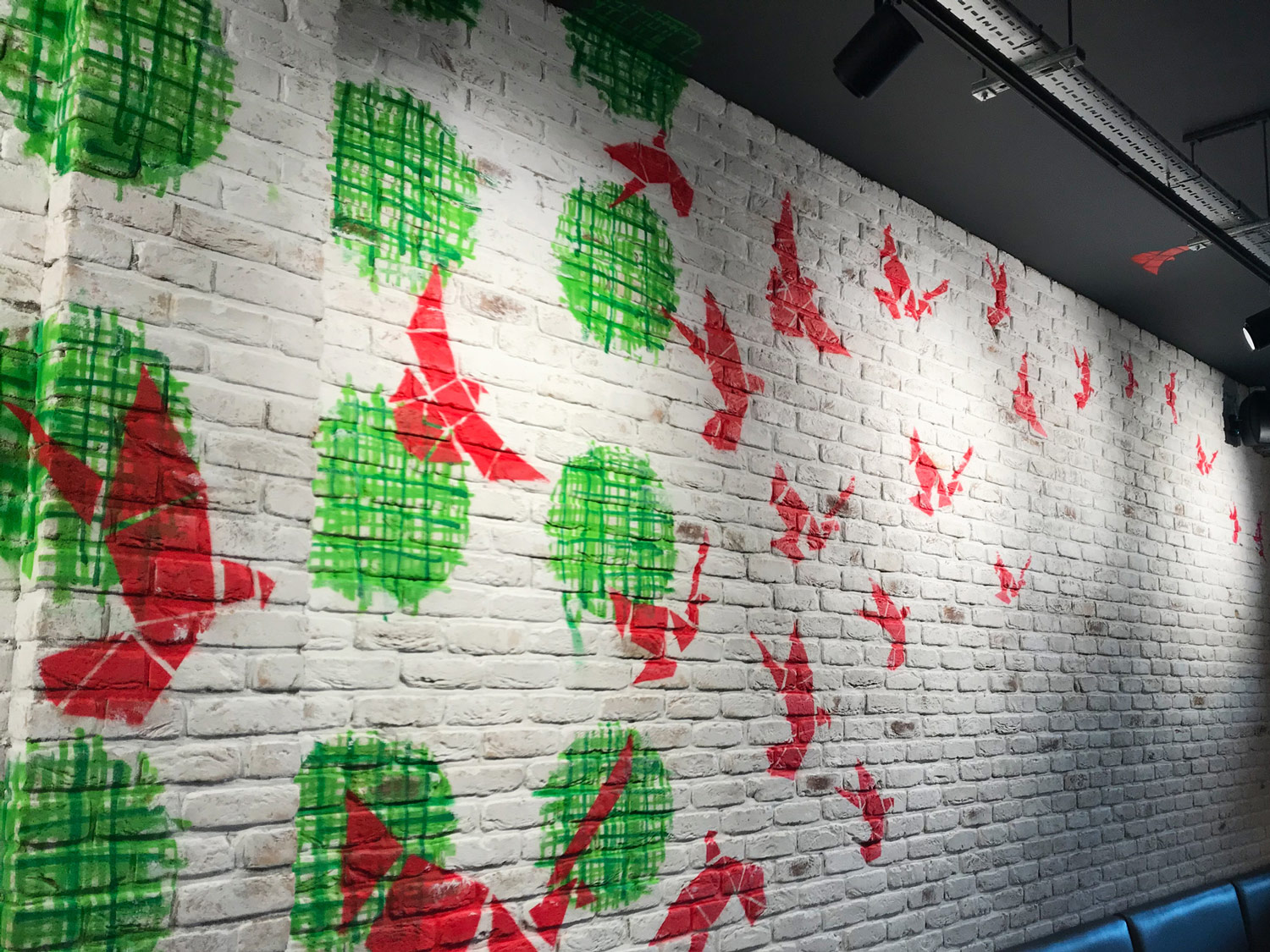red birds and green circles on a white brick background