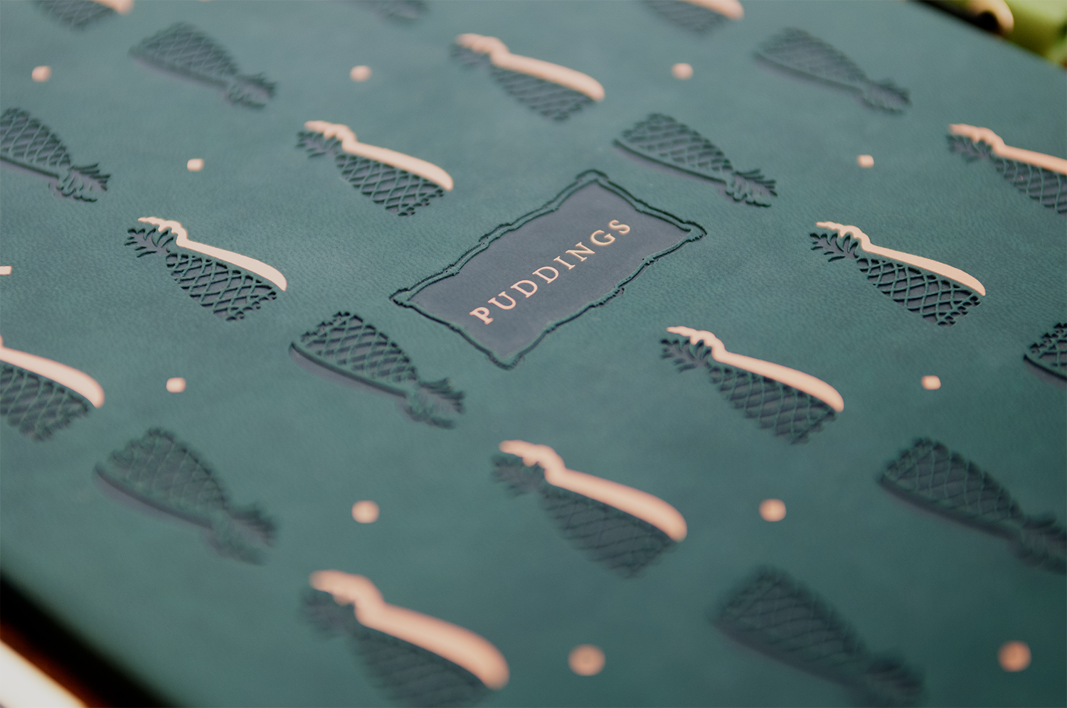 Close up of embossed green leather pudding menu cover