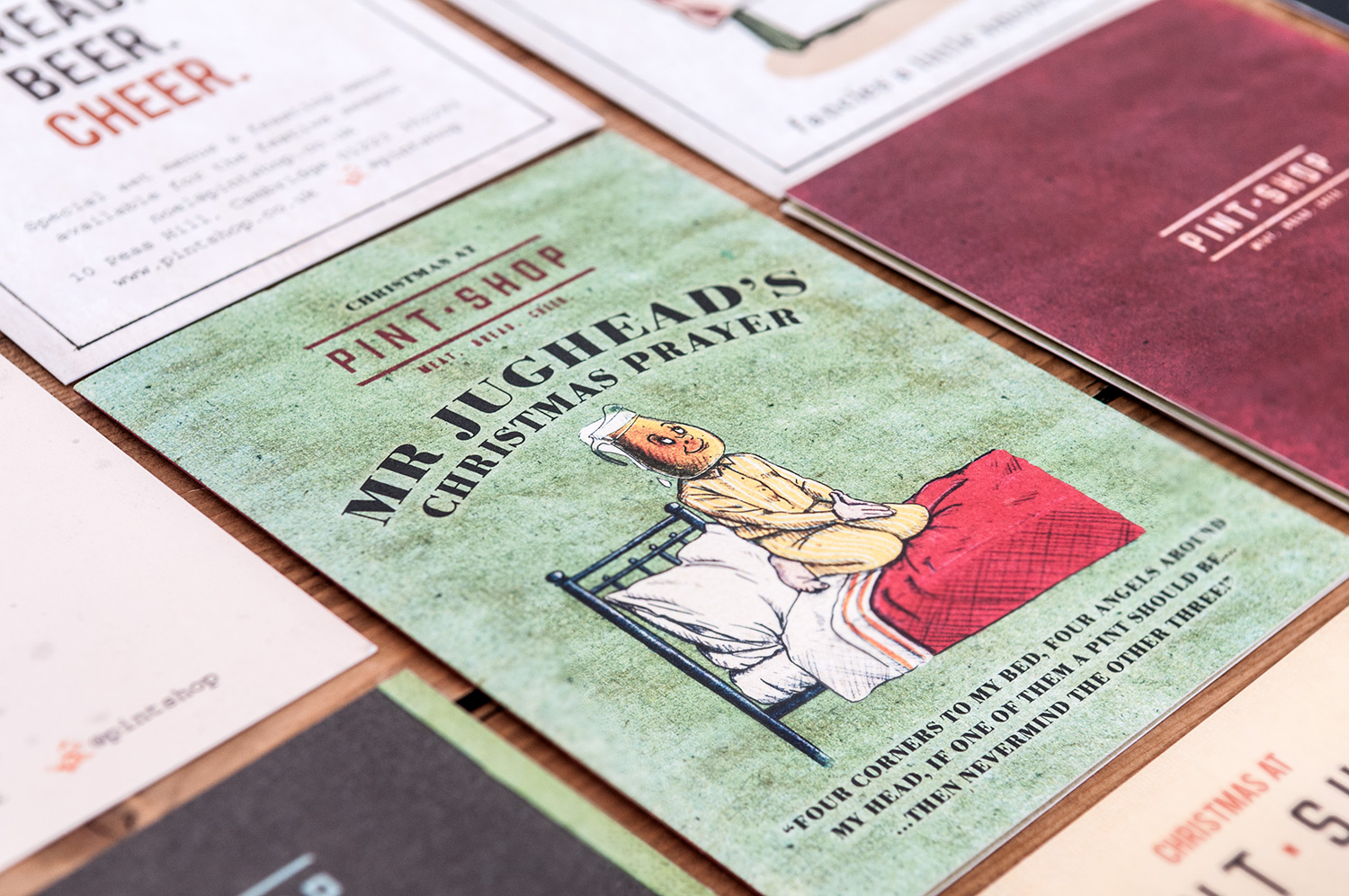 Close-up of a flat lay of various green postcards with vintage styled characters for Pint Shop marketing collateral, designed by SAINT Design.
