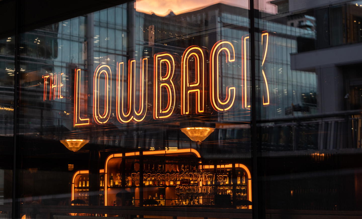 The Lowback logo as a neon sign in the window of the bar, by SAINT Design for Hawksmoor.